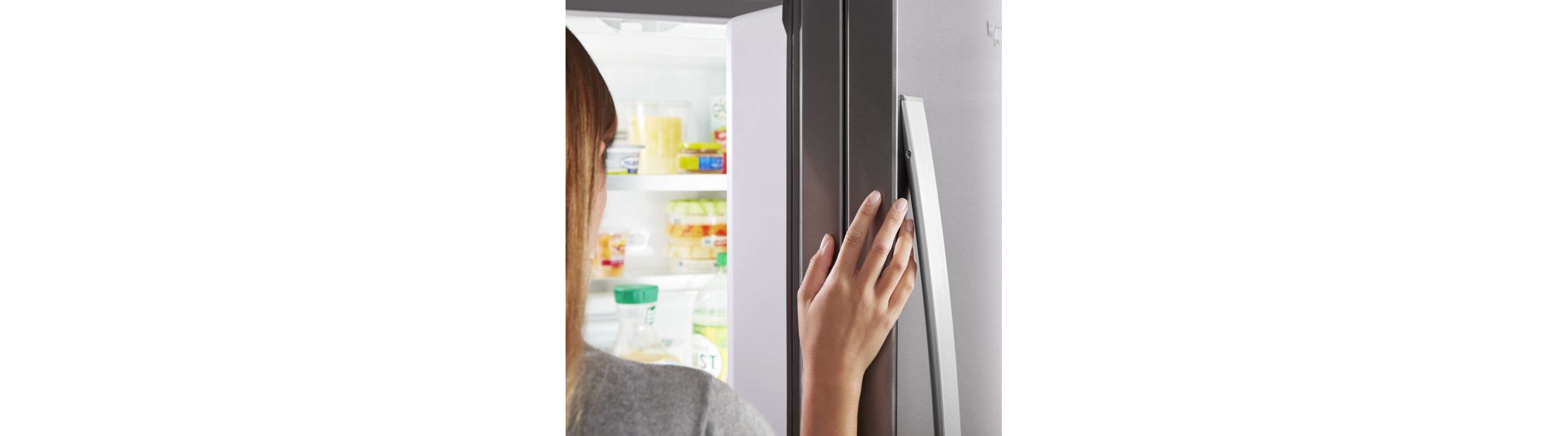 Close-up of a person’s hand on a fingerprint-resistant refrigerator door 