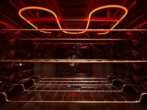 The inside of an empty oven with the burners glowing