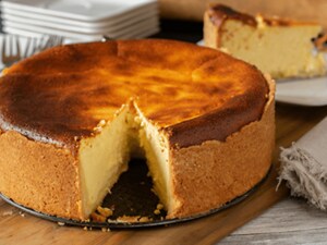 A cheesecake on a tray with one piece cut out