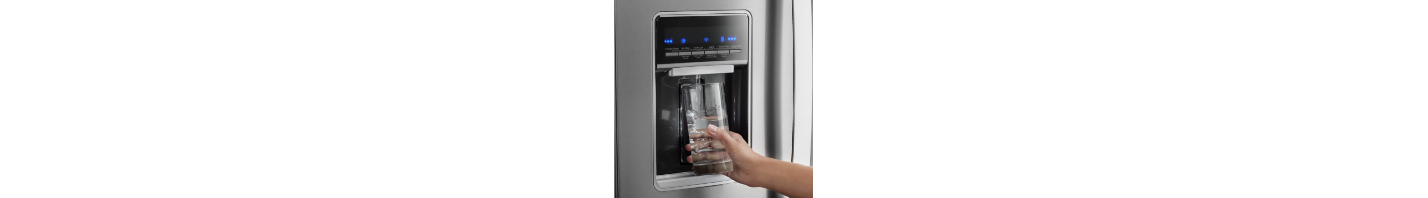 A person filling their glass from a refrigerator water dispenser
