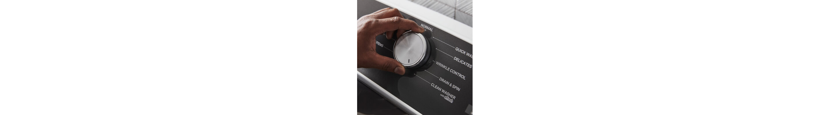 Close up of a person selecting a washer setting on the control panel of a Whirlpool® Washer