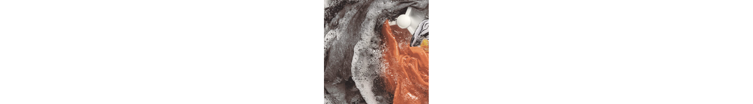 Interior of a Whirlpool® Washer with an impeller washing orange, gray and white garments
