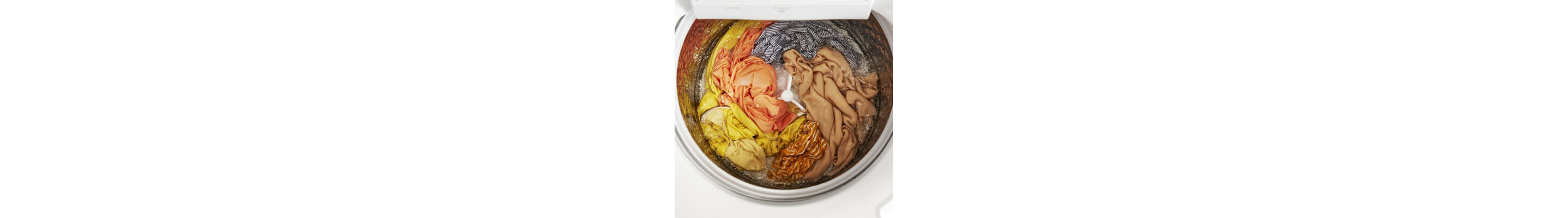 Interior of a Whirlpool® Washer with an impeller washing yellow, orange, gray and brown garments