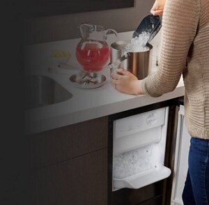 Someone shoveling ice into a container at a countertop