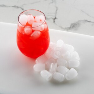 Bullet ice on tray and in a glass with red beverage