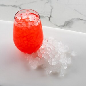 Nugget ice on tray and in a glass with red beverage