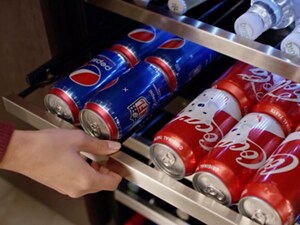 Someone pulling out a drawer of sodas in a beverage center