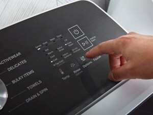 A person operating the control panel of their washer