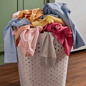 A laundry basket filled with mixed clothes