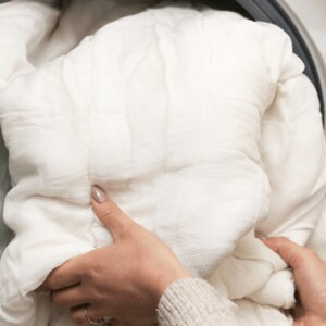 Someone handling a comforter in their laundry