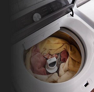 An open washing machine, filled with clothing