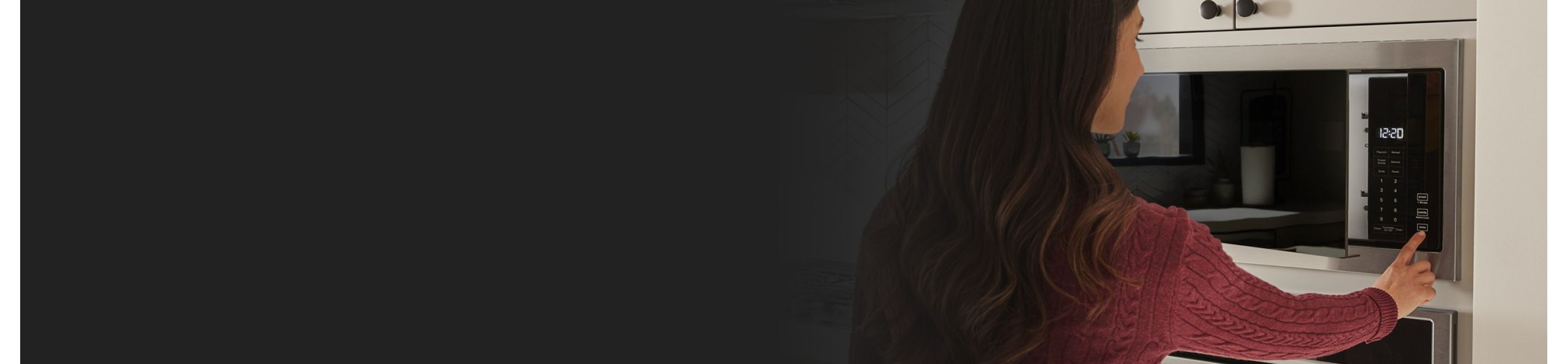 A profile view of a person using a microwave.