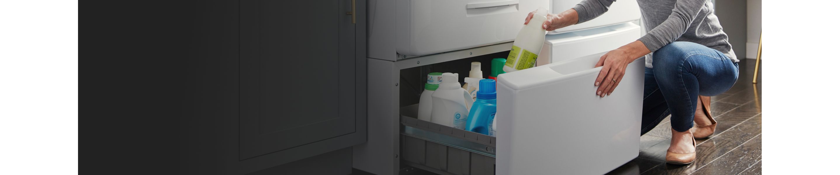  A woman placing laundry detergent in a washer pedestal
