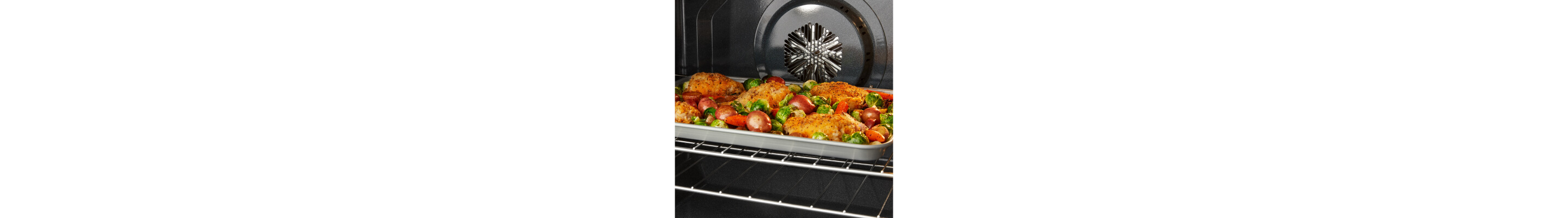 Food cooking on a sheet pan in the oven