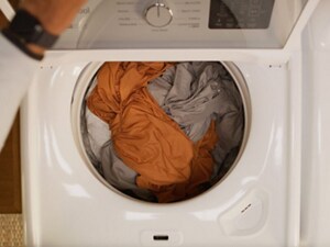 An open washing machine with clothes inside