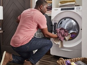 Person loading laundry in an all-in-one washer dryer