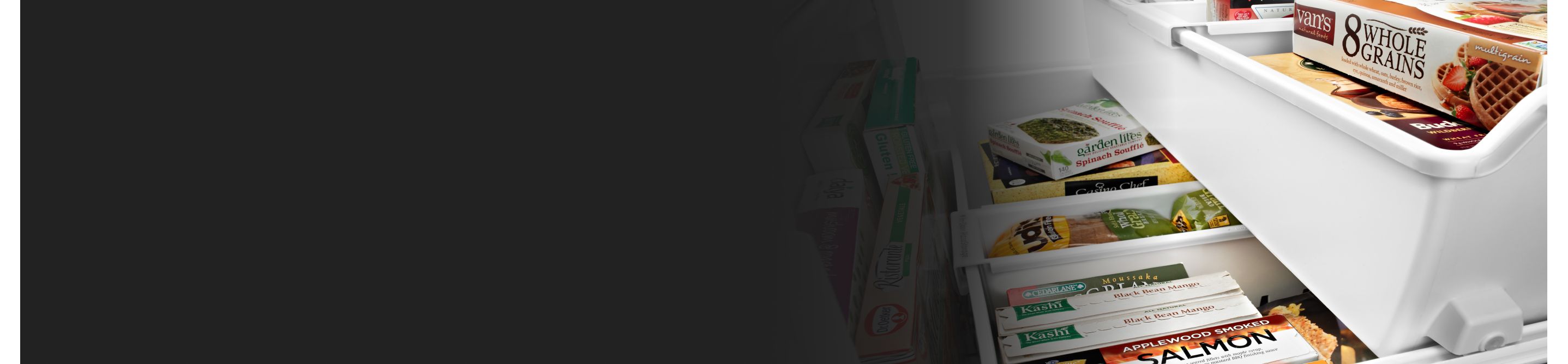 A variety of frozen groceries in the freezer compartment of a white refrigerator