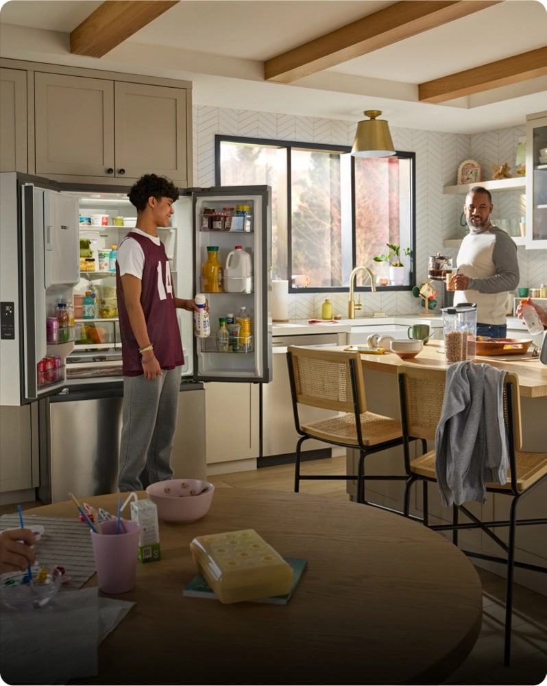 Two people preparing breakfast for their family inside a bright, modern kitchen