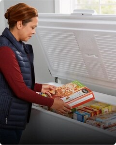 A person removing frozen food from their Whirlpool® Chest Freezer
