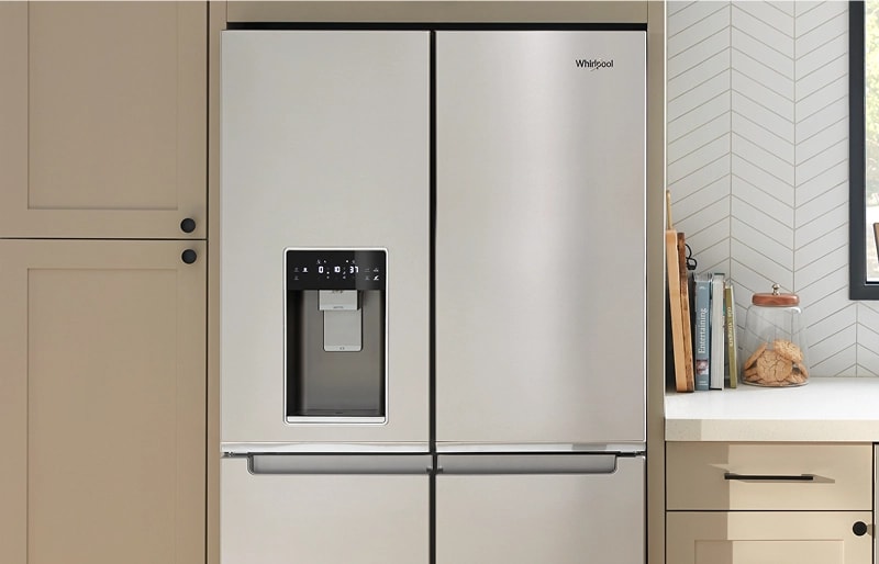 A sleek stainless steel four door refrigerator inside of a kitchen