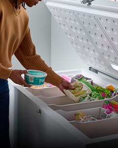 A person removing frozen food from their Whirlpool® Chest Freezer