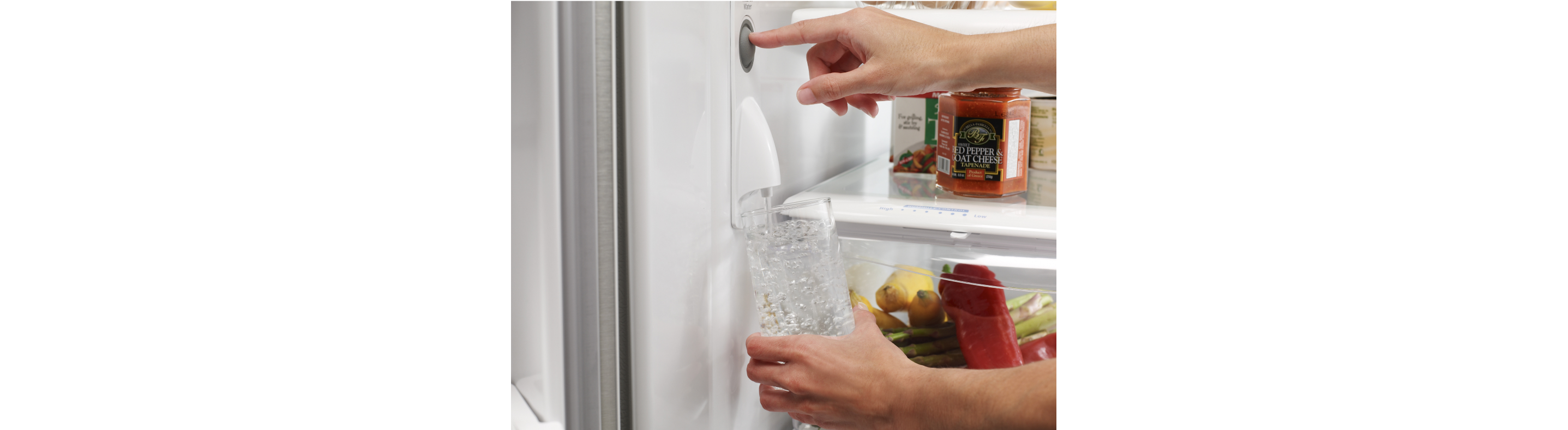 Filling a glass from an internal refrigerator water dispenser.